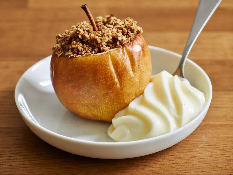 Bratapfel mit Hafer-Zimt-Füllung und einem Löffel Vanillesauce
